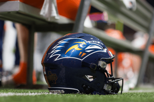 UTSA Football helmet on field under a bench