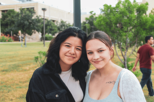 two students standing arm in arm