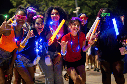 A group of students posing with glow sticks