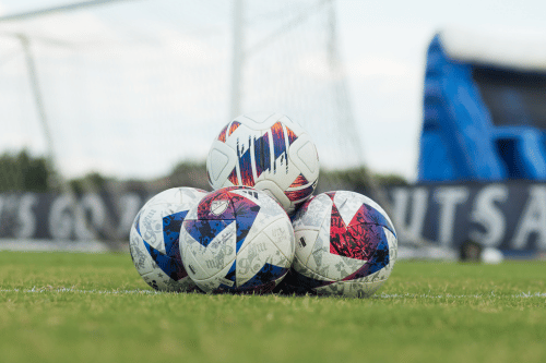 four soccer balls stacked in pyramid on UTSA soccer field