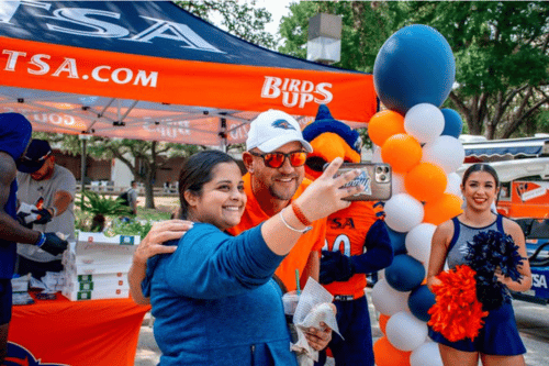 person taking a selfie with Coach Traylor and Rowdy