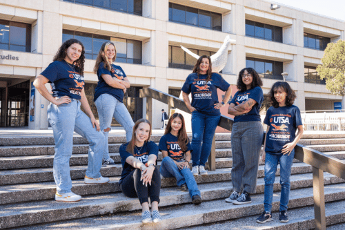 group of students on the stairs in front of the Roadrunner statue