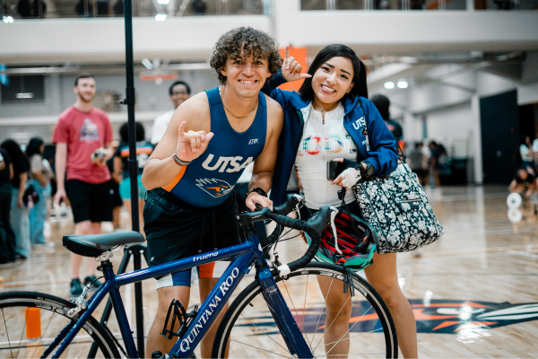 two students with a bicycle in the Campus Recreation Center