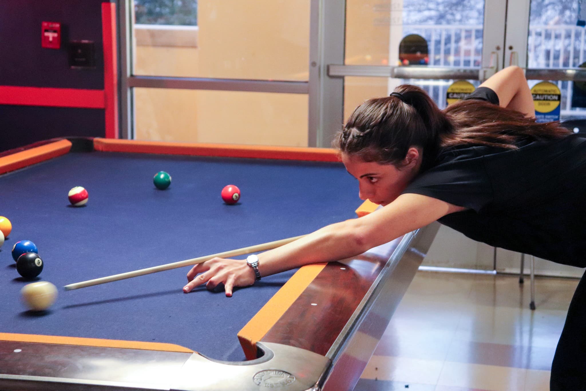 student lining up her billiards shot