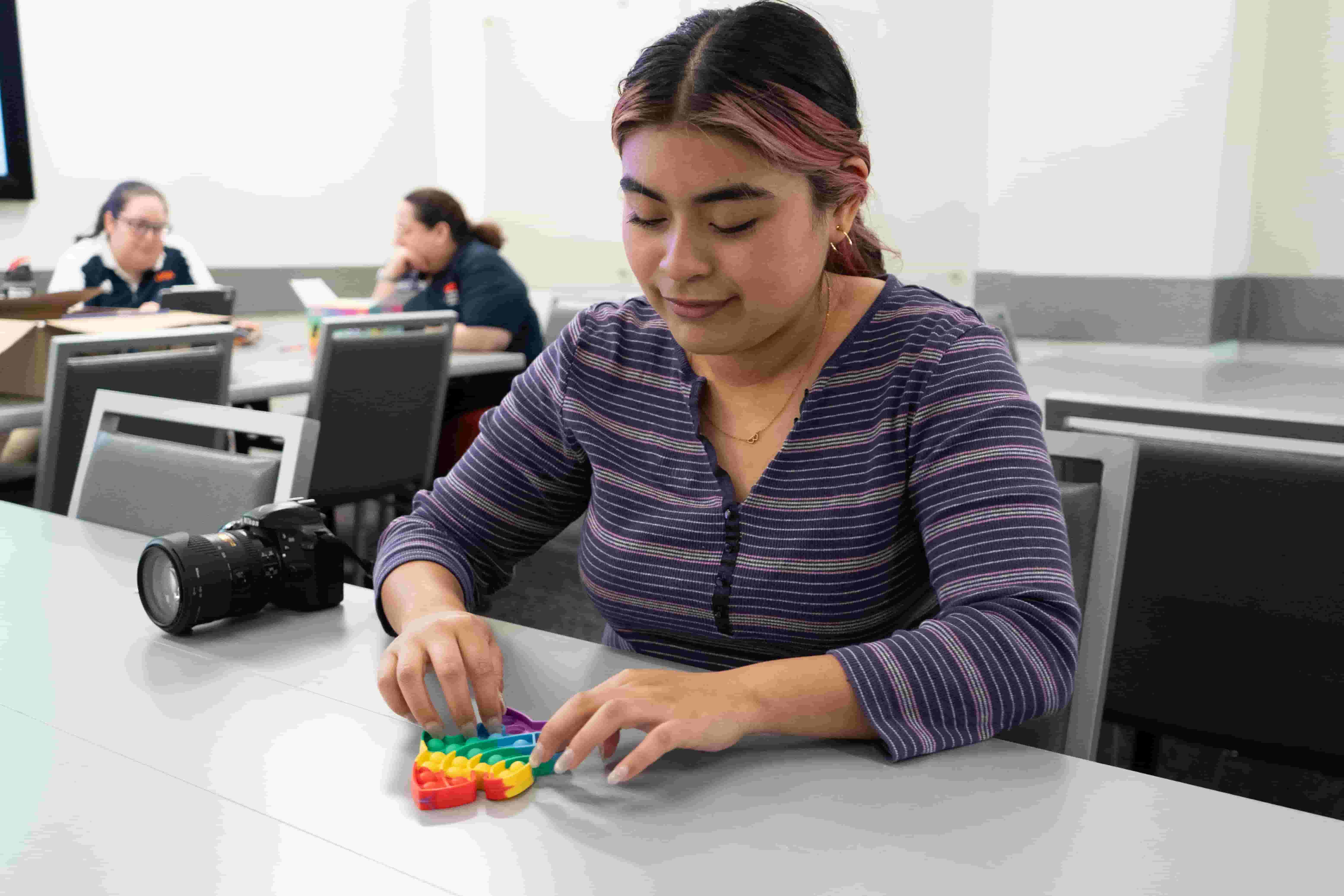 student playing with a pop fidget toy