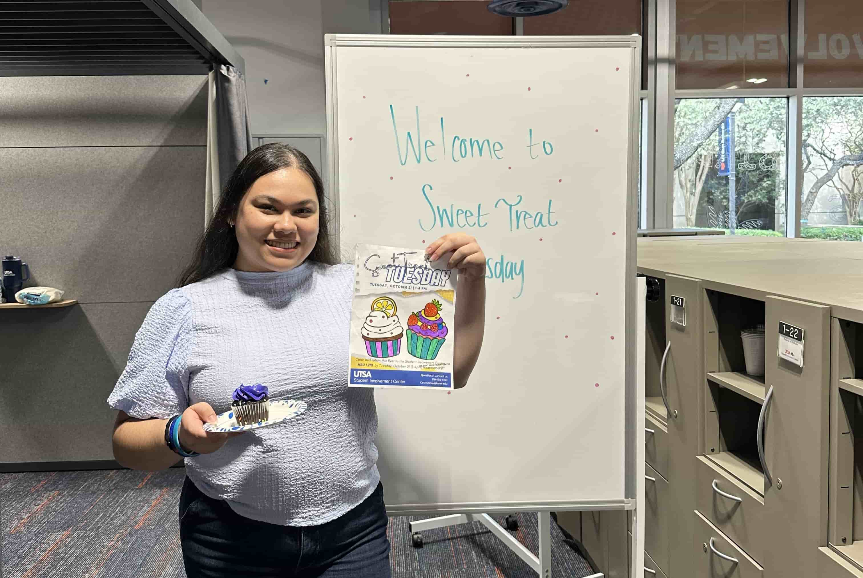 student holding a cupcake at the Sweet Treat event