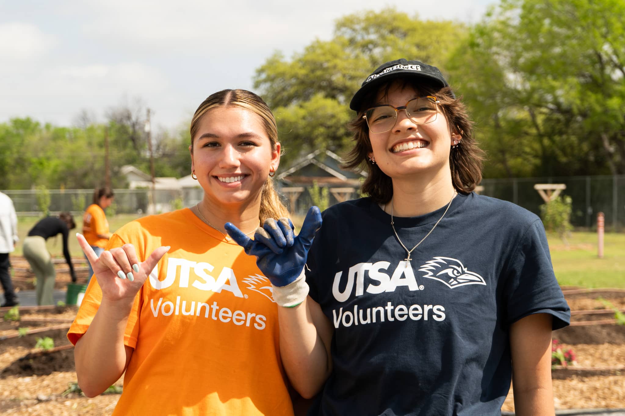 two students at a volunteer gardening event