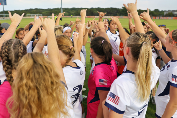 UTSA Soccer team in a huddle with their Birds Up