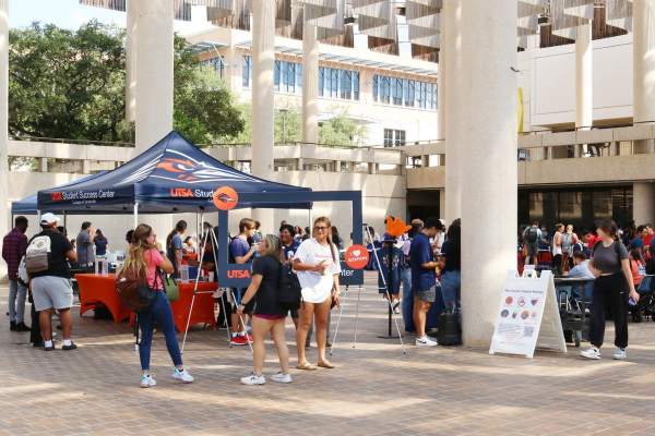 students browsing tables in the Sombrilla Plaza