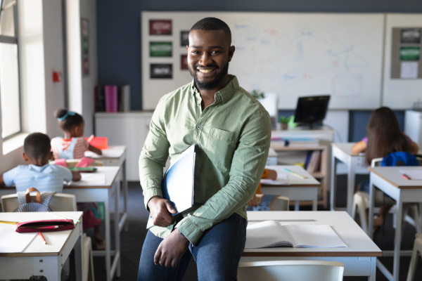 male teacher leaning on desk